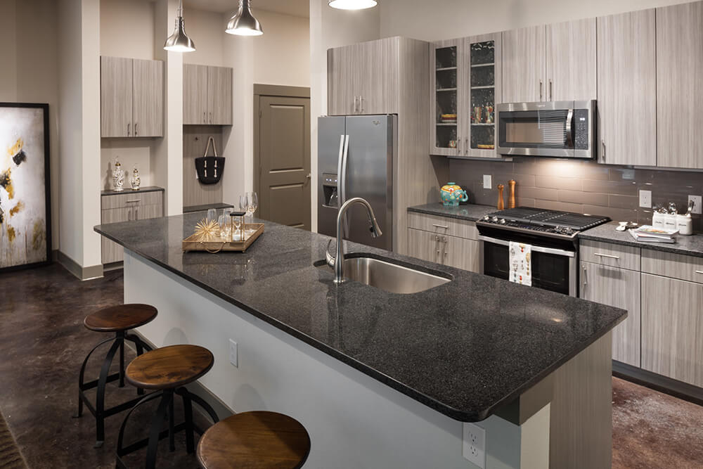 Alexan crossing grey linen multifamily kitchen cabinets with dark grey quartz countertops